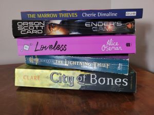 Four books, all from the course syllabus, stacked on top of each other.