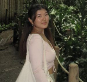 Ayumi is an asian woman wearing pale clothes among tyhe foliage