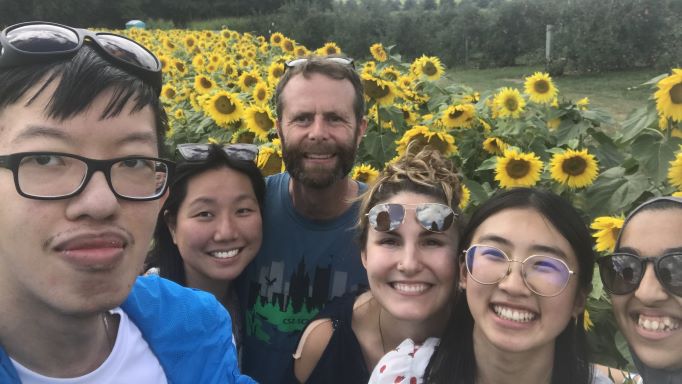 Sinclair lab in a selfie with sunflowers in the background