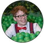 image of Carlie, the web site's author in glasses, a bowtie, and suspenders in a green ball pit