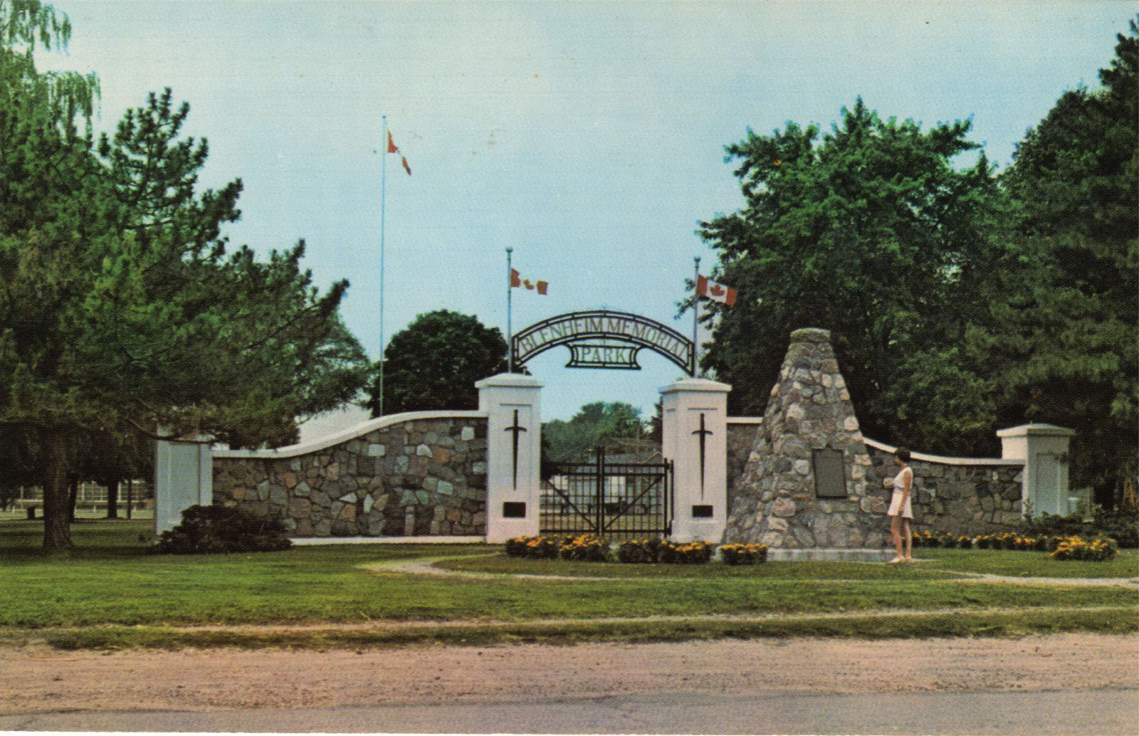 memorial park front gate entrance, flower garden, woman standing out front